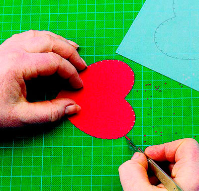 Отриману заготівлю покладіть на килимок і за допомогою скальпеля зробіть маленькі трикутні прорізи у кожної олівцевої позначки по периметру серця
